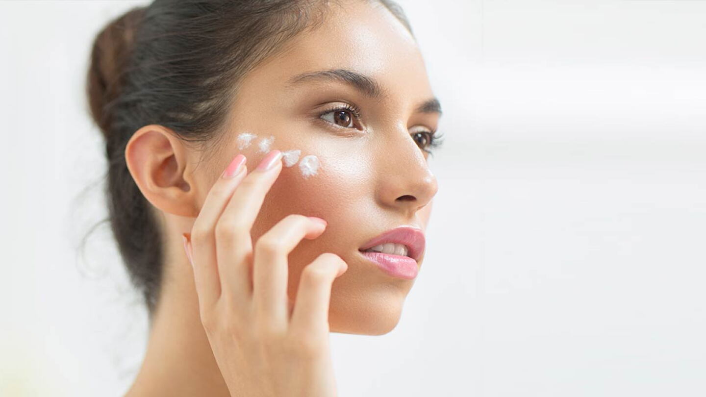 Mujer utilizando protector solar facial