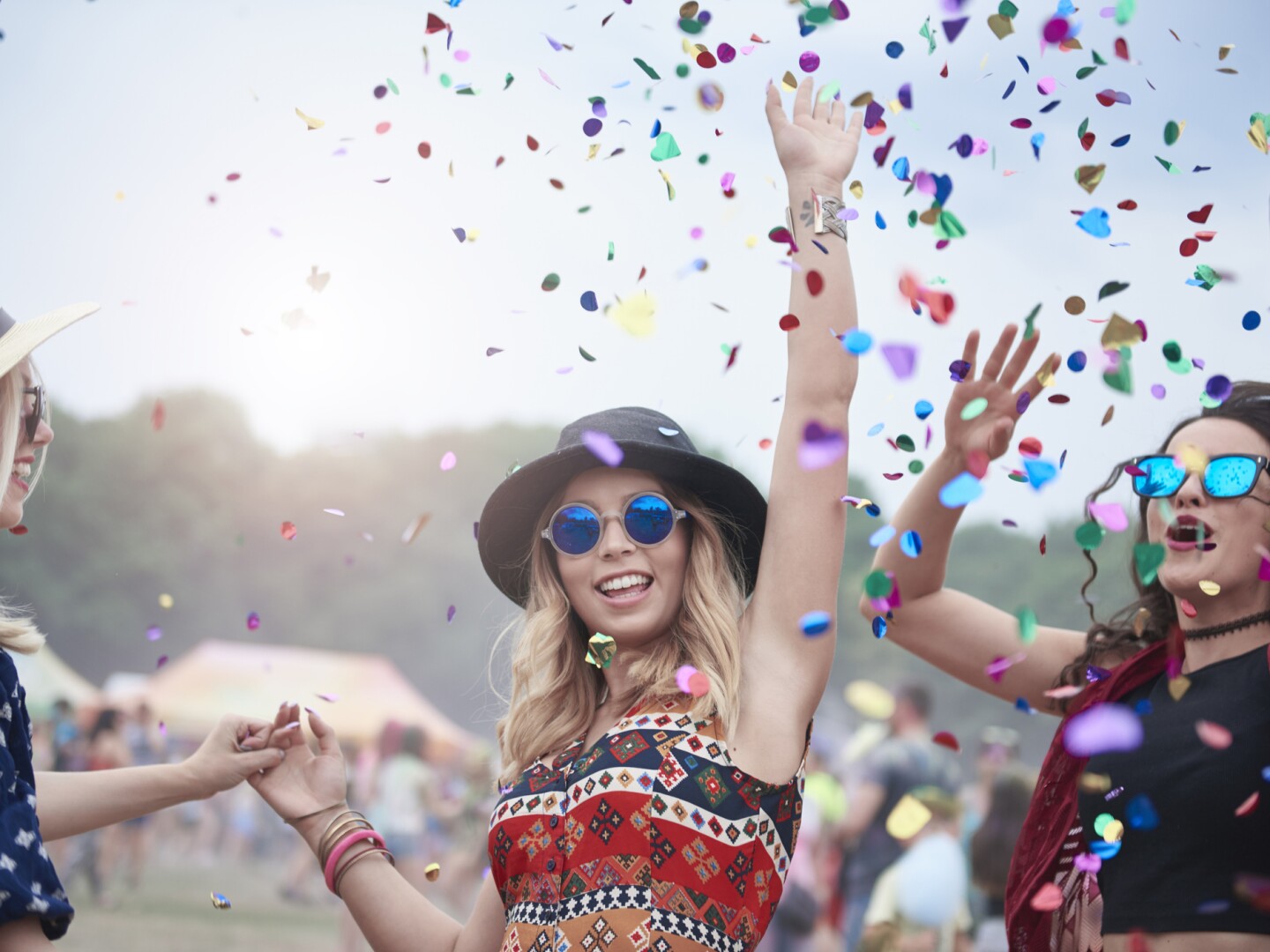 Friends dancing among confetti at the music festival
