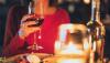 persona en una cena sosteniendo una copa de vino