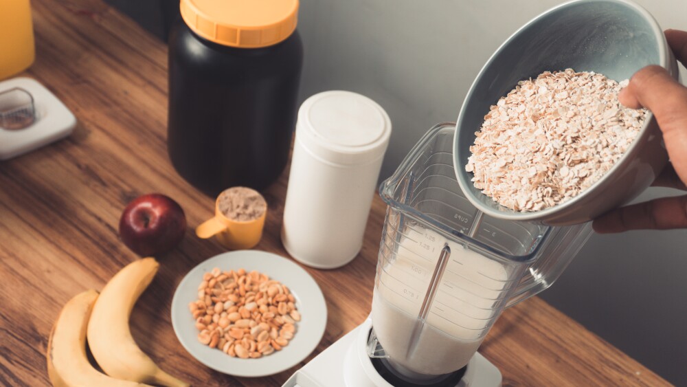 Pov preparing a protein shake with oatmeal,banana and peanut.
