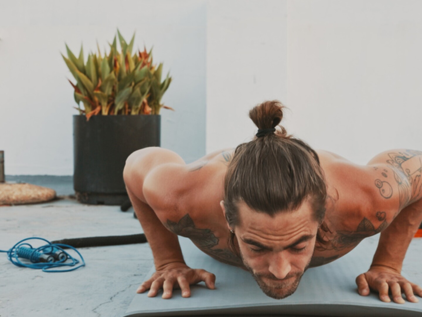 Cropped shot of a handsome young man working out alone and doing pushups on the rooftop during the day
